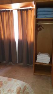 圣拉斐尔Departamento San Rafael - Sobre Paseo Chile的一间卧室配有床和带毛巾的架子