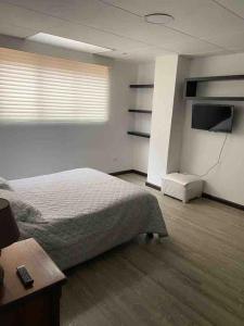 昆卡Departamento entero sector Oro Verde的一间卧室配有一张床和一台平面电视