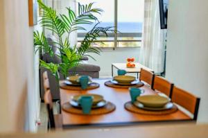 美洲海滩Ocean View Penthouse的桌子上放有盘子和杯子