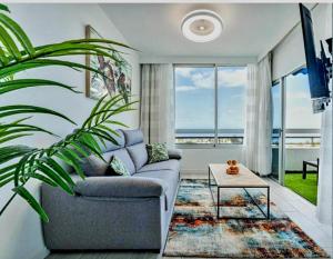 美洲海滩Ocean View Penthouse的客厅配有沙发和桌子