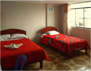 卡哈马卡Hotel San Francisco的一间卧室配有两张床和红色毯子