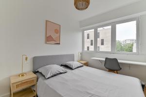 巴涅奥莱CityStay full brand new appartement 3 bedrooms 5min to Paris的一间卧室配有一张床、一张书桌和一个窗户。