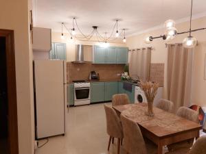 格兰贝伊Summersun Residence的厨房配有桌子和白色冰箱。