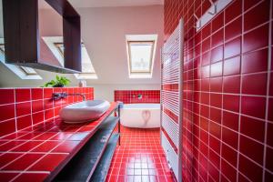 根特Casa Mina - Dok Noord Ghent的红色的浴室设有浴缸和红色瓷砖