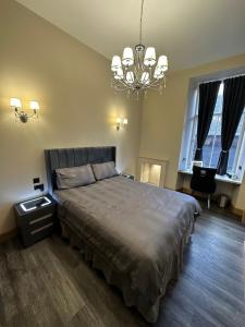 爱丁堡Thistle City Inn的一间卧室配有一张大床和一个吊灯。