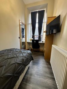爱丁堡Thistle City Inn的一间卧室配有一张床和一张带电脑的书桌