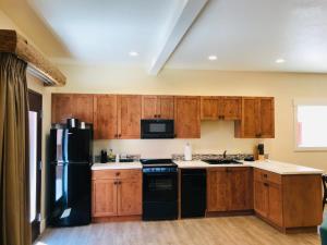 布拉夫Bluff Dwellings Resort的厨房配有木制橱柜和黑色冰箱。