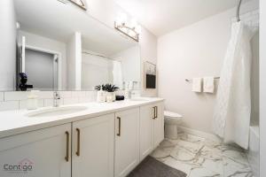 埃德蒙顿Boho Luxe Home, Sleeps 12, AirCon, King Bed, WiFi的白色的浴室设有水槽和卫生间。