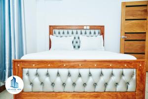 林贝Atlantic View Apartments的一间卧室配有一张带白色床单的木床