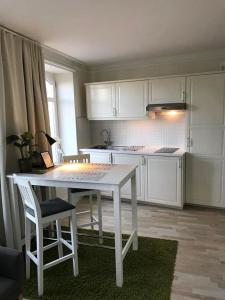 赫尔辛堡Lilla Drottninggatan Apartment Hotel的白色的厨房配有白色的桌子和椅子