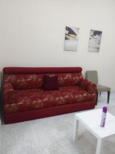 沙迦استوديو مفروش的客厅里一张红色的沙发,配有桌子