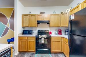 FruitlandThe Garrison Getaway的厨房配有木制橱柜和黑色冰箱。