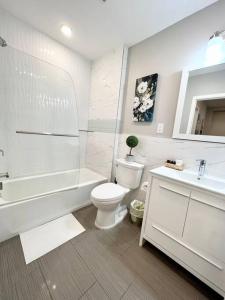 费城305 Cozy and lovely 1BDR apartment in Center City的白色的浴室设有卫生间、浴缸和水槽。