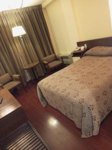 拉巴斯Eldorado的酒店客房带一张床、一张桌子和椅子