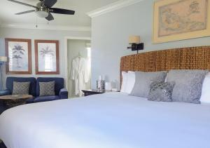 卡皮托拉Capitola Hotel的卧室配有白色的床和蓝色椅子