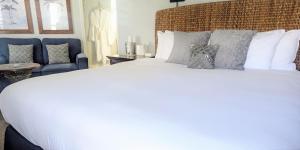 卡皮托拉Capitola Hotel的卧室配有白色大床和蓝色椅子