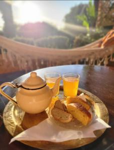 丹吉尔Hajrienne guest house的盘子,带茶壶和两杯橙汁