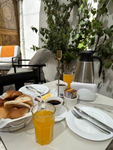 阿雷基帕Hotel Piru Wasi的包括面包、咖啡和橙汁的早餐桌