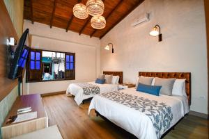 萨兰托萨伦托瑞尔酒店及咖啡厅的一间卧室配有两张床和一台平面电视
