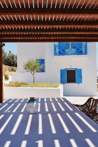 伊奥斯乔拉Villa Giulia, seaview villa的一个带蓝色桌椅的庭院和一座房子