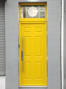 伦敦德里No.5的建筑上一扇黄色的门,上面有标志