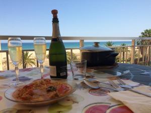 卡耐特蒂贝兰格Vacaciones Canet Playa - en primera linea的一张桌子,上面放着一瓶香槟和一盘比萨饼