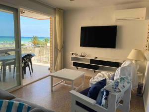 卡耐特蒂贝兰格Vacaciones Canet Playa - en primera linea的带沙发、电视和桌子的客厅