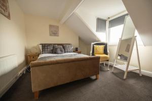 南希尔兹The Beach House -South Shields的阁楼卧室配有床和椅子