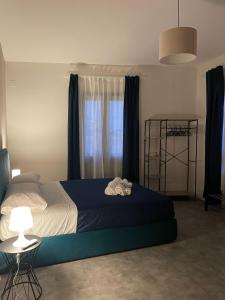 帕奥拉Dimora 7 fontane的一间卧室配有一张带蓝色毯子的床和窗户。