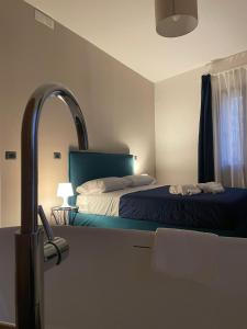 帕奥拉Dimora 7 fontane的一间卧室配有一张带绿色床头板和镜子的床