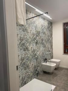 帕奥拉Dimora 7 fontane的浴室设有卫生间和水槽,配有壁纸