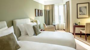 波尔图波尔图皇冠假日酒店的配有一张床和一张书桌的酒店客房