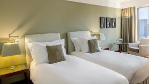 波尔图波尔图皇冠假日酒店的酒店客房设有两张床和窗户。