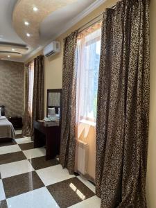 埃里温Royal Plus Hotel的一间卧室配有床和带窗帘的窗户