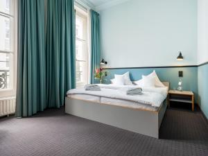 汉堡奥森阿尔斯特酒店的一间卧室配有一张带绿色窗帘的大床