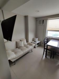 马尼拉Monalisa Gilmore Tower的客厅配有白色的沙发和桌子