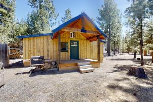 CrescentLittle Pine Cabin at Big Pine Retreat的森林中带绿门的小木屋