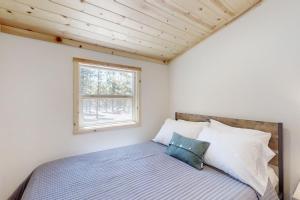 CrescentLittle Pine Cabin at Big Pine Retreat的一间卧室设有一张床和一个窗口