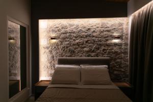 帕尔加Elais Luxury Villas的一间卧室配有一张石墙床
