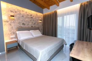 帕尔加Elais Luxury Villas的一间卧室设有一张床和一个大窗户
