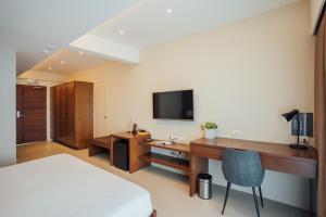 马比尼Solitude Acacia Resort的一间卧室配有一张床和一张书桌及电视