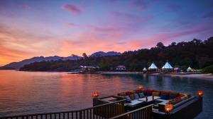 立咯海滩兰卡威丽思卡尔顿酒店的日落时分享有湖泊上的度假村景致