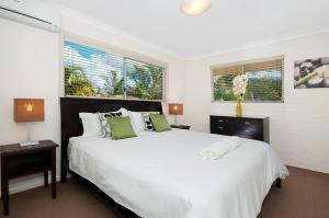 拜伦湾Shivas@Byron... minutes walk to Main Beach!的卧室设有一张白色大床和两个窗户。