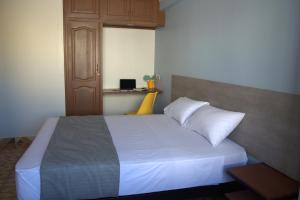 科恰班巴Izza Hotel的一间卧室配有带白色床单和枕头的床。