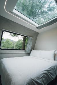 冬山乡天ㄟ露營車的一间卧室设有一张床和一个窗口