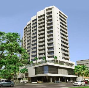 圣克鲁斯Departamento Elegante y Relax by Torre Vento的一座高大的白色建筑,前面有棕榈树