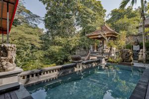 乌布Tigata Ubud Cottage的后院的游泳池,带凉亭