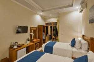 乌布Tigata Ubud Cottage的酒店客房设有两张床和电视。