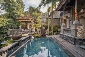 乌布Tigata Ubud Cottage的房屋前有游泳池的房子