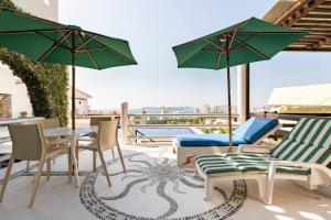 阿卡普尔科Hermosa Villa Puesta al SOL的一个带桌椅和遮阳伞的庭院